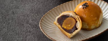 Design concept of Moon cake yolk pastry, mooncake for Mid-Autumn Festival holiday on dark gray table background