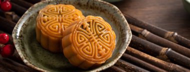 Delicious Cantonese moon cake for Mid-Autumn Festival food mooncake on wooden table background for afternoon tea, holiday celebration serving.