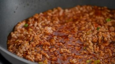 Homemade stir-frying ground pork with hot spicy sauce when cooking mapo tofu cuisine at home