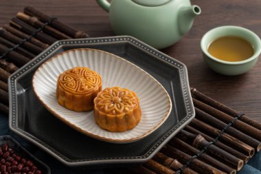 Delicious Cantonese moon cake for Mid-Autumn Festival food mooncake on wooden table background for afternoon tea, holiday celebration serving.