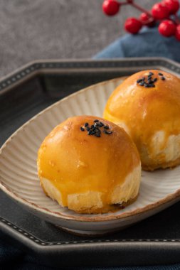 Design concept of Moon cake yolk pastry, mooncake for Mid-Autumn Festival holiday on dark gray table background