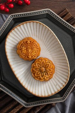 Delicious Cantonese moon cake for Mid-Autumn Festival food mooncake on wooden table background for afternoon tea, holiday celebration serving.