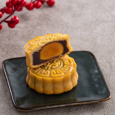 Delicious Cantonese moon cake for Mid-Autumn Festival food mooncake on gray table background for afternoon tea, holiday celebration serving.