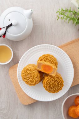 Delicious Cantonese moon cake for Mid-Autumn Festival food mooncake on wooden table background for afternoon tea, holiday celebration serving.