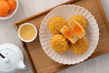 Delicious Cantonese moon cake for Mid-Autumn Festival food mooncake on wooden table background for afternoon tea, holiday celebration serving.