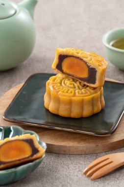 Delicious Cantonese moon cake for Mid-Autumn Festival food mooncake on gray table background for afternoon tea, holiday celebration serving.