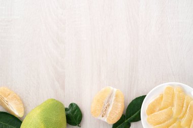 Güz ortası meyve festivali için parlak ahşap masa arkasında soyulmuş taze pomelo manzarası.