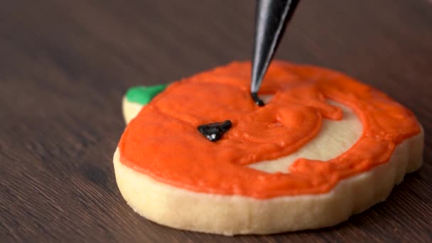 かわいいハロウィンのカボチャのジンジャーブレッドクッキーを飾るの終わりアイシングクリームトッピングバッグ 砂糖クッキーを作る — ストック動画