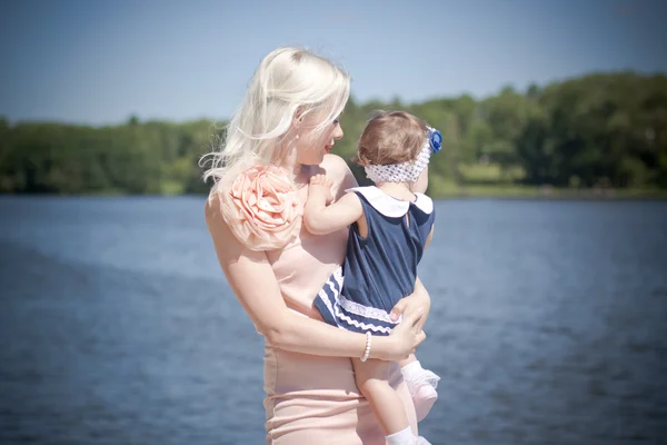 Beautiful blond hait mother and daughter in the park — Stock Photo, Image