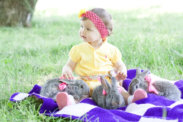 Мила дитина з кроликами на відкритому повітрі — стокове фото