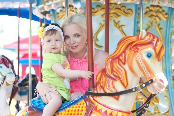 Happy matka a dcera na karuselu — Stock fotografie