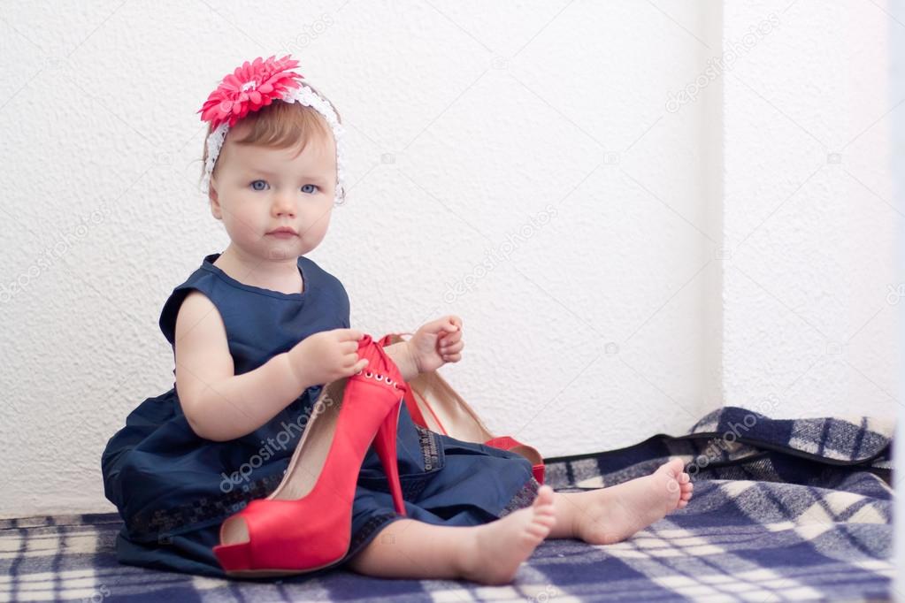Child is holding adult high heel shoe