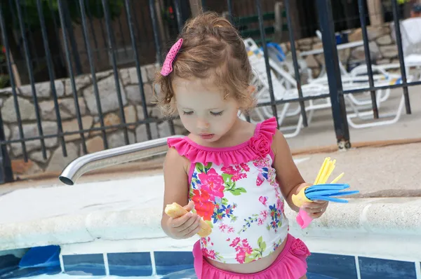 Roztomilá holčička se baví v bazénu — Stock fotografie
