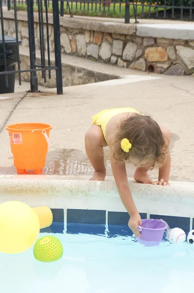 Roztomilá holčička se baví v bazénu — Stock fotografie