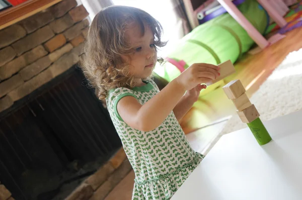 Cute baby girl is playing with wooden blocks — Stock Photo, Image