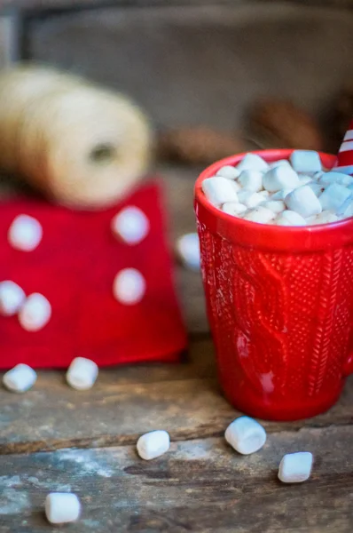 红色针织杯子，装有热巧克力和棉花糖，木制底座 — 图库照片