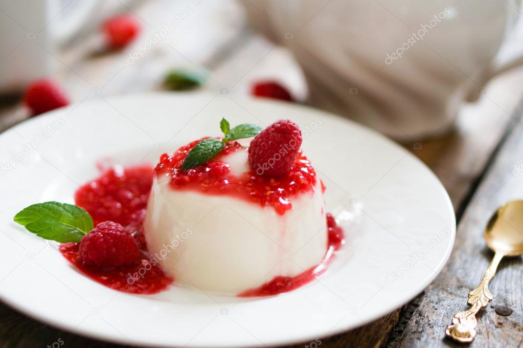Delicious italian dessert panna cotta with raspberry sauce and mint