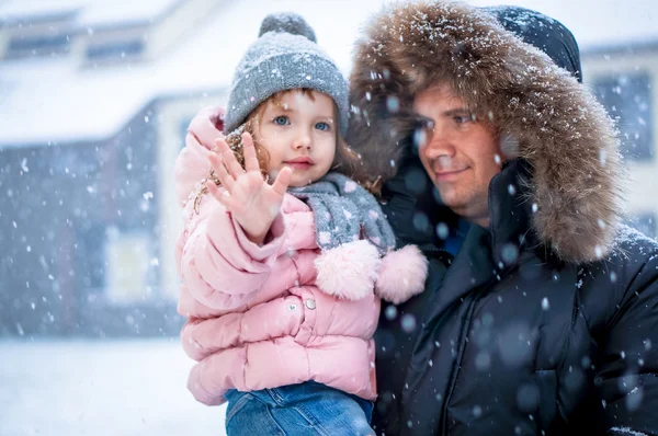 Far och dotter enhoying snö blåser på dagtid — Stockfoto