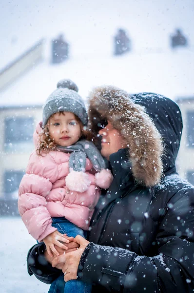 Far och dotter enhoying snö blåser på dagtid — Stockfoto