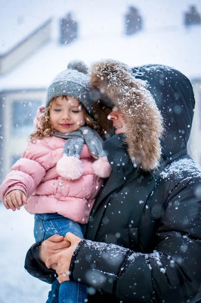 Батько і дочка, що дме снігом вдень — стокове фото