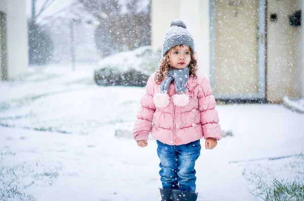 Carino bambino in giacca rosa e cappello grigio godendo prima neve b — Foto Stock