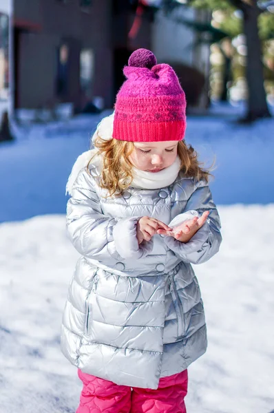 Söt baby tjej njuter av första snön — Stockfoto