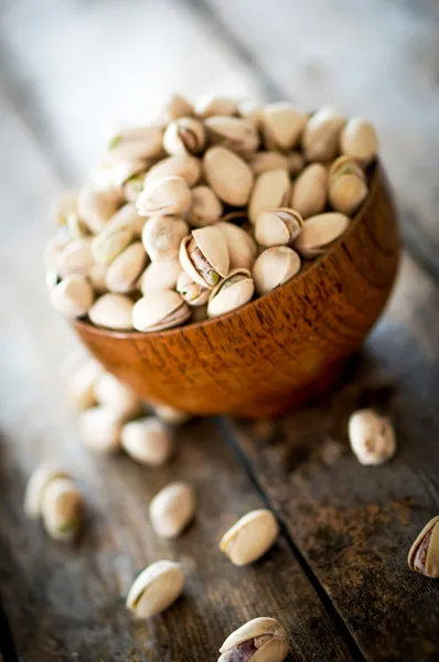 Close-up of roasted pistachios on wooden background — Stock Photo, Image