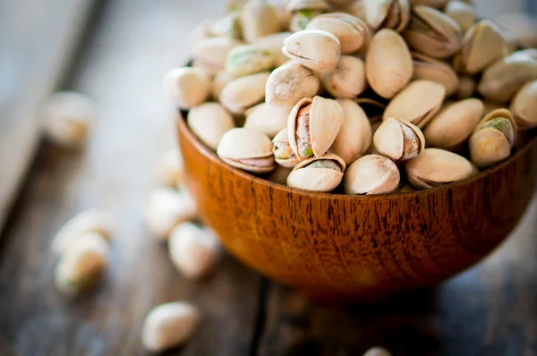 Close-up of roasted pistachios on wooden background — Stock Photo, Image