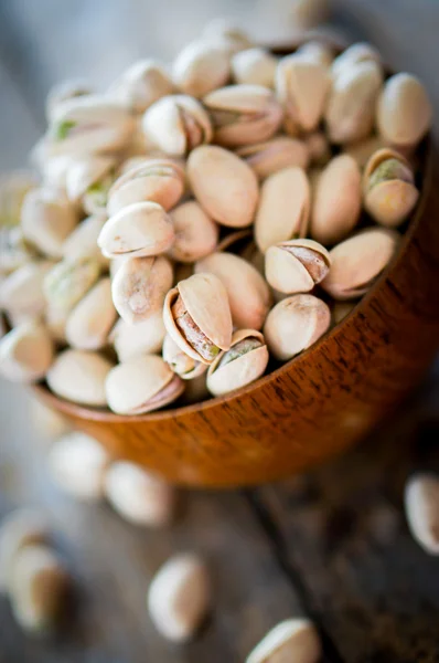 Close-up of roasted pistachios on wooden background — Stock Photo, Image