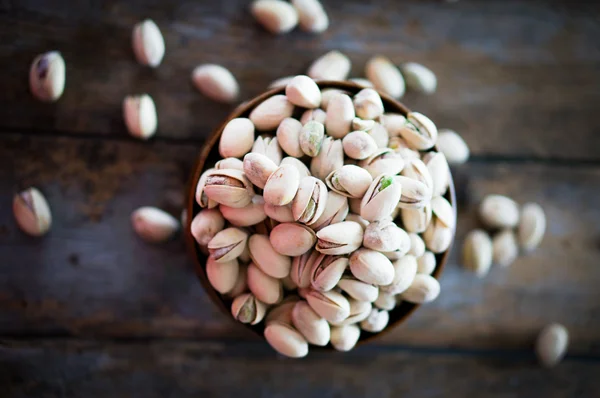 Close-up of roasted pistachios on wooden background — Stock Photo, Image