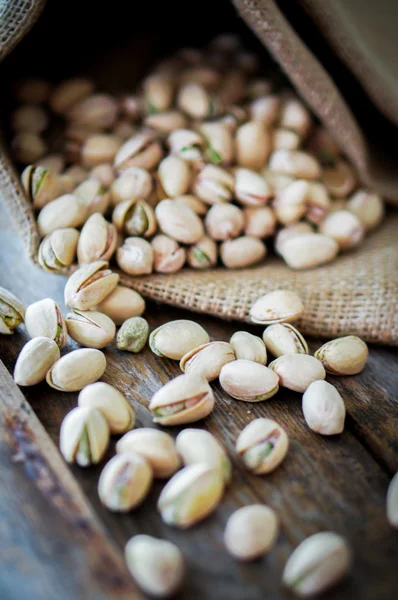 Close-up of roasted pistachios on wooden background — Stock Photo, Image