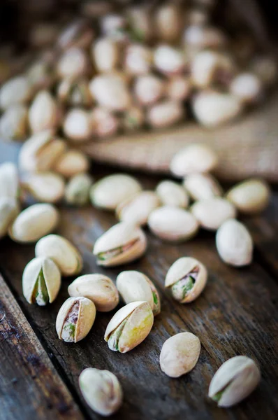 Close-up of roasted pistachios on wooden background — Stock Photo, Image