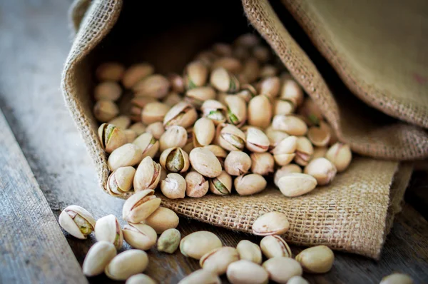 Close-up of roasted pistachios on wooden background — Stock Photo, Image