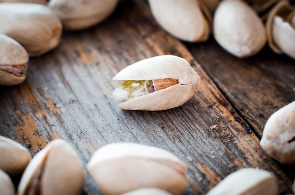 Close-up of roasted pistachios on wooden background — Stock Photo, Image