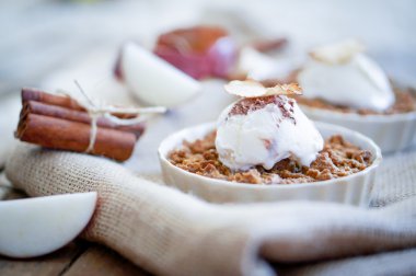 Apple crumble dessert with cinnamon and vanilla ice -cream on wooden background clipart