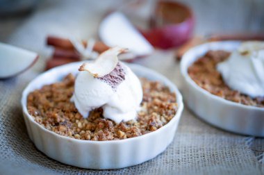 Apple crumble dessert with cinnamon and vanilla ice -cream on wooden background clipart