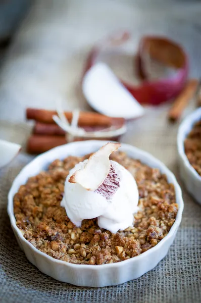 Apple crumble dessert with cinnamon and vanilla ice -cream on wooden background — Stock Photo, Image