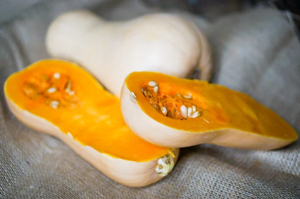 Ungekochter, in Scheiben geschnittener Butternut-Kürbis auf Holzgrund — Stockfoto