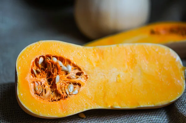 Courge musquée tranchée non cuite sur fond de bois — Photo