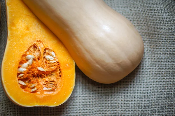 Uncooked sliced butternut squash on wooden background — Stock Photo, Image