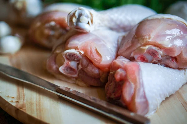 Fresh raw chicken legs on kitchen cutting board with dill and garlic — Stock Photo, Image