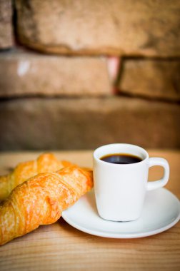 Ahşap arka plan üzerinde siyah kahve ile siyah ay çöreği