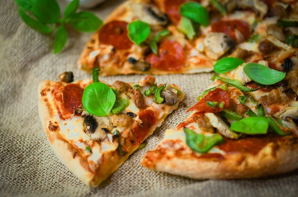 Pizza de pepperoni casera en rodajas sobre fondo rústico de madera — Foto de Stock