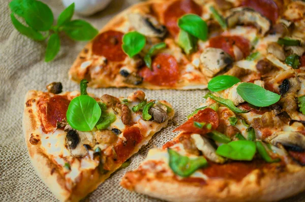 Sliced home made pepperoni pizza on wooden rustic background — Stock Photo, Image