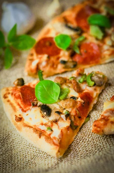 Sliced home made pepperoni pizza on wooden rustic background — Stock Photo, Image