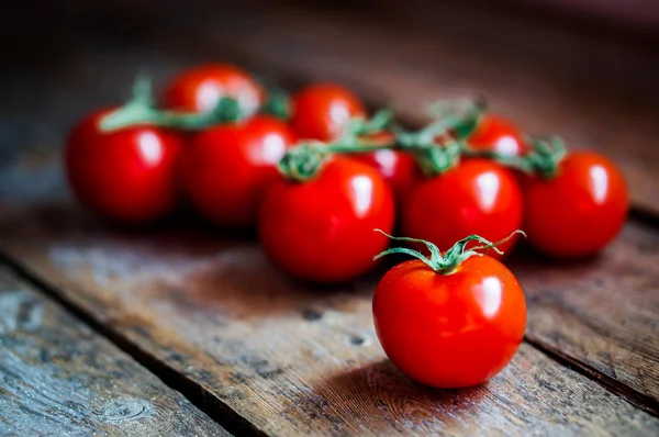 Sarmaşıktaki domatesler ahşap arka planda — Stok fotoğraf