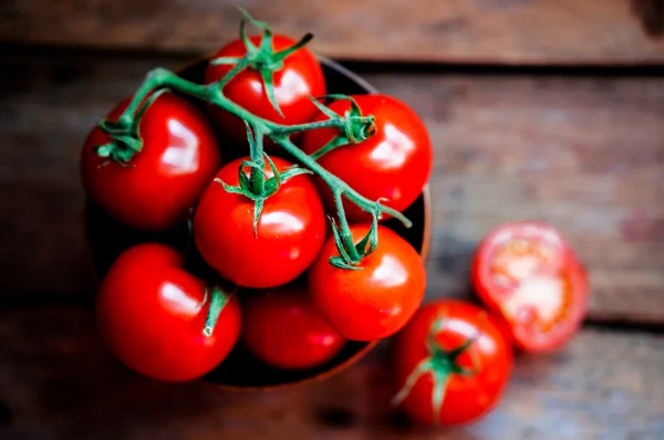 Tomates en la cesta sobre fondo de madera — Foto de Stock