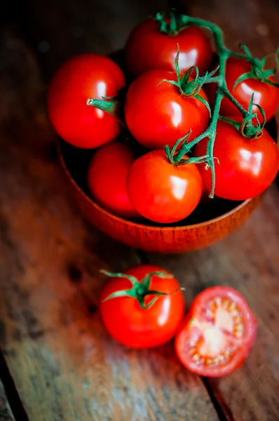 Tomates en la cesta sobre fondo de madera — Foto de Stock