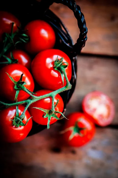 Tomates en la cesta sobre fondo de madera — Foto de Stock