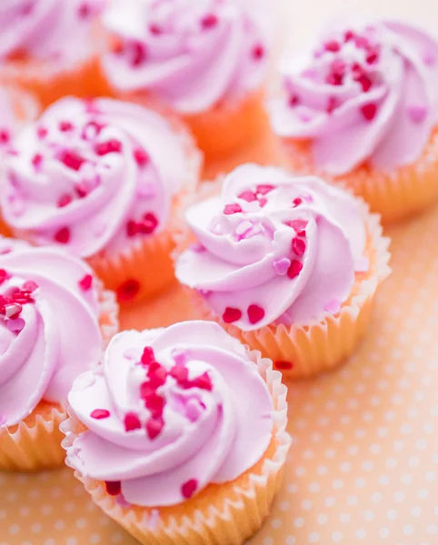 Cupcakes con crema rosa y chispas de corazón — Foto de Stock